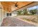 Covered patio with a ceiling fan overlooking the backyard and lake at 730 Buckskin Ct, Englewood, FL 34223