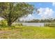 Expansive waterfront view with lush greenery and a glimpse of houses across the tranquil lake at 730 Buckskin Ct, Englewood, FL 34223