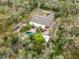 Aerial shot of a home with a pool, surrounded by mature trees and featuring a long, private driveway at 746 Brentwood Dr, Venice, FL 34292