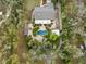 Aerial view of the property featuring a swimming pool and circular patio surrounded by lush trees and landscaping at 746 Brentwood Dr, Venice, FL 34292