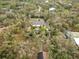 An aerial view of a secluded home surrounded by trees, featuring a pool and landscaped yard at 746 Brentwood Dr, Venice, FL 34292