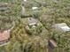Aerial view of a home with a pool and lush landscaping, nestled among tall trees and winding driveways at 746 Brentwood Dr, Venice, FL 34292