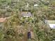 Aerial view of a secluded home amidst trees, showcasing a pool and a curving driveway entrance at 746 Brentwood Dr, Venice, FL 34292