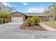 Charming brick home featuring an attached two-car garage, a paved walkway, and tropical landscaping at 746 Brentwood Dr, Venice, FL 34292