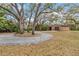 Circular driveway leads to a detached garage and a well-landscaped front yard with mature trees at 746 Brentwood Dr, Venice, FL 34292