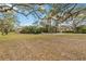 Expansive front lawn with mature trees and lush greenery, creating a serene and private setting at 746 Brentwood Dr, Venice, FL 34292