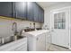Convenient laundry room features modern washer, dryer, sink, and ample cabinet space at 746 Brentwood Dr, Venice, FL 34292