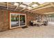 A covered brick patio with outdoor furniture and sliding glass doors to the interior at 746 Brentwood Dr, Venice, FL 34292