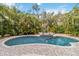 Backyard pool area surrounded by tropical landscaping and a brick patio at 746 Brentwood Dr, Venice, FL 34292