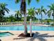 Community pool area with palm trees, lounge chairs, and a clear blue swimming pool at 8409 Placida Rd # 305, Placida, FL 33946