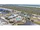 Aerial view of a community pool with palm trees, tennis courts, and a clubhouse at 8409 Placida Rd # 305, Placida, FL 33946