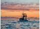 Vibrant ocean sunset reflecting off the water behind a shrimping boat at sea at 8896 Gulf St, Placida, FL 33946