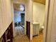 Hallway with view to a bathroom with light blue sink vanity and toilet; walls needing renovation at 8896 Gulf St, Placida, FL 33946