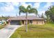 Charming home with stone accents, fresh landscaping, and inviting driveway leading to an attached garage at 9260 Saint Catherine Ave, Englewood, FL 34224
