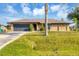 Attractive single-story home with attached two-car garage, well-maintained lawn and mature landscaping at 9260 Saint Catherine Ave, Englewood, FL 34224