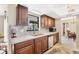 Well-lit kitchen featuring wood cabinets, tile backsplash, and stainless-steel dishwasher at 9260 Saint Catherine Ave, Englewood, FL 34224