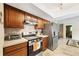 Modern kitchen featuring wood cabinets, stainless steel appliances, and stylish backsplash at 9260 Saint Catherine Ave, Englewood, FL 34224
