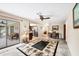 Open-concept living room with tile flooring, ceiling fan, and sliding glass doors to the lanai at 9260 Saint Catherine Ave, Englewood, FL 34224