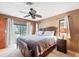 The main bedroom is spacious with a ceiling fan and access to the outdoor patio at 9260 Saint Catherine Ave, Englewood, FL 34224