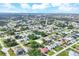 Aerial showcases the community with many homes and mature trees; lake visible in distance at 9260 Saint Catherine Ave, Englewood, FL 34224