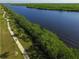 Scenic aerial view of river with green banks and a concrete walkway and pedestrian at 9382 Rosebud Cir, Port Charlotte, FL 33981