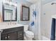 Clean bathroom featuring a dark vanity, toilet, and tub with a decorative turtle curtain at 9382 Rosebud Cir, Port Charlotte, FL 33981