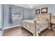 Cozy bedroom with a rustic bed frame, wood floors, and natural light from a large window at 9382 Rosebud Cir, Port Charlotte, FL 33981