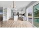 Open kitchen with stainless steel appliances, white cabinets, island, and views of the pool area at 9382 Rosebud Cir, Port Charlotte, FL 33981