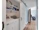 Convenient laundry room features a modern washer and dryer, barn door, and plenty of shelving for storage at 9382 Rosebud Cir, Port Charlotte, FL 33981