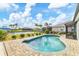 Sparkling pool with brick paver patio, canal views, and lush landscaping at 9382 Rosebud Cir, Port Charlotte, FL 33981
