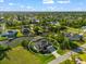 Waterfront home with attached boat dock, well-manicured lawn, and neighborhood surrounded by tropical landscaping at 10491 Sarasota Rd, Port Charlotte, FL 33981