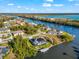 Aerial view showcasing a home with a solar panel array and screened pool, nestled along a waterfront canal at 10491 Sarasota Rd, Port Charlotte, FL 33981