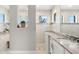 Elegant bathroom featuring granite countertops, dual mirrors, and a walk-in shower at 10491 Sarasota Rd, Port Charlotte, FL 33981