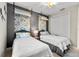 Cozy bedroom with two twin beds, stylish wall decor, and a ceiling fan at 10491 Sarasota Rd, Port Charlotte, FL 33981