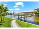 A private dock with boat lift and waterfront views surrounded by lush greenery and blue skies at 10491 Sarasota Rd, Port Charlotte, FL 33981