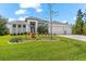 Charming home featuring a three-car garage, lush lawn, and unique landscaping at 10491 Sarasota Rd, Port Charlotte, FL 33981
