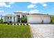 A contemporary home featuring a three-car garage, lush lawn, and mature landscaping at 10491 Sarasota Rd, Port Charlotte, FL 33981