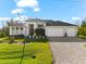 Stunning contemporary home featuring a three-car garage, meticulously landscaped yard, and inviting entrance at 10491 Sarasota Rd, Port Charlotte, FL 33981