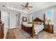 Bright main bedroom with a four-poster bed, ceiling fan, and decorative touches at 10491 Sarasota Rd, Port Charlotte, FL 33981