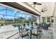 Relaxing screened-in patio shows tile flooring, outdoor dining and seating with a water view at 10491 Sarasota Rd, Port Charlotte, FL 33981