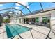 Expansive screened-in patio features a pool, dining, and seating areas with access to the main house at 10491 Sarasota Rd, Port Charlotte, FL 33981
