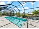 A bright screened-in pool has stone tiling with outdoor steps and waterfront views adding relaxation at 10491 Sarasota Rd, Port Charlotte, FL 33981