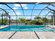 The screened in pool has stone tiling and a waterfront view adding luxury and relaxation at 10491 Sarasota Rd, Port Charlotte, FL 33981