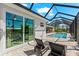 Sun loungers sit by the doors to a screened in pool with access to the main house at 10491 Sarasota Rd, Port Charlotte, FL 33981
