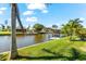 View of the waterway showing covered boat dock and well-maintained lawn with tropical landscaping at 10491 Sarasota Rd, Port Charlotte, FL 33981