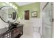 Bathroom with a stand-up shower, modern sink with large mirror, and decorative accents at 1052 Newton St, Englewood, FL 34224