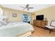Well-lit bedroom featuring wood-look floors, a ceiling fan, and an exit to the lanai at 1052 Newton St, Englewood, FL 34224