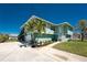 Charming two-story home with a beautiful lawn, palm trees, and a paved driveway at 1052 Newton St, Englewood, FL 34224
