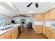 Open concept kitchen with wooden cabinets, white countertops, stainless steel appliances and access to the living room at 1052 Newton St, Englewood, FL 34224