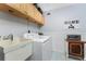 Bright laundry room with a utility sink and storage, featuring a modern washer and dryer set at 1052 Newton St, Englewood, FL 34224